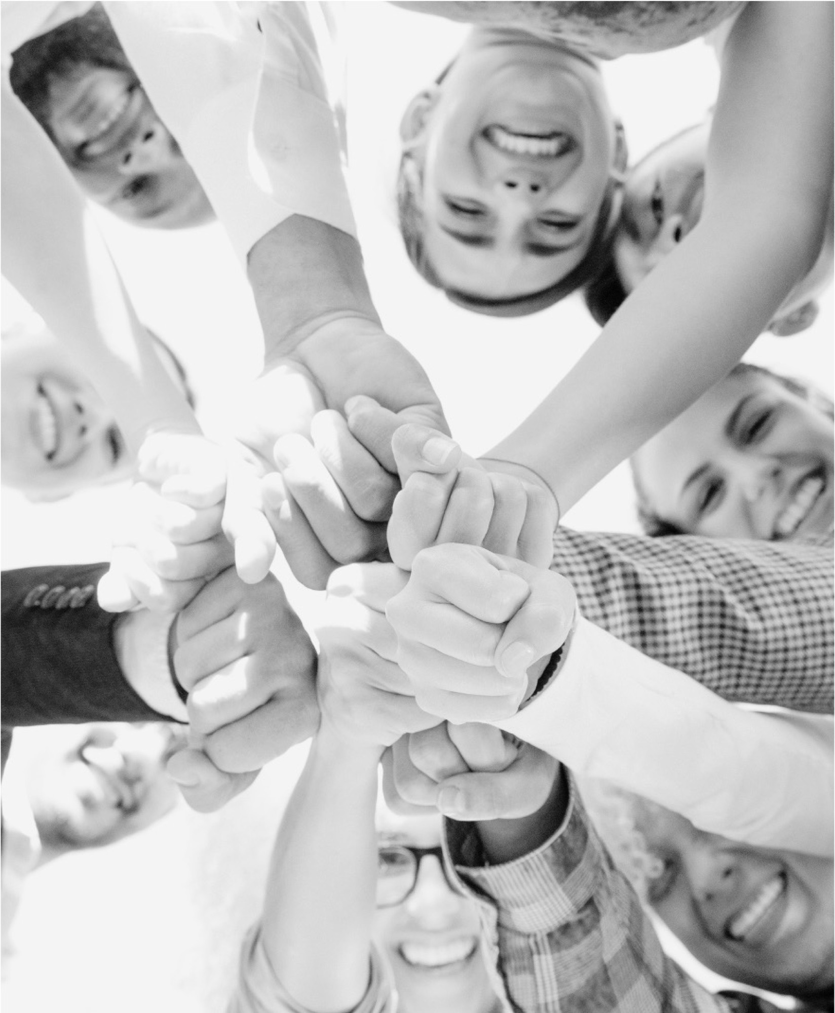 A group of young people, hands joined in the middle.